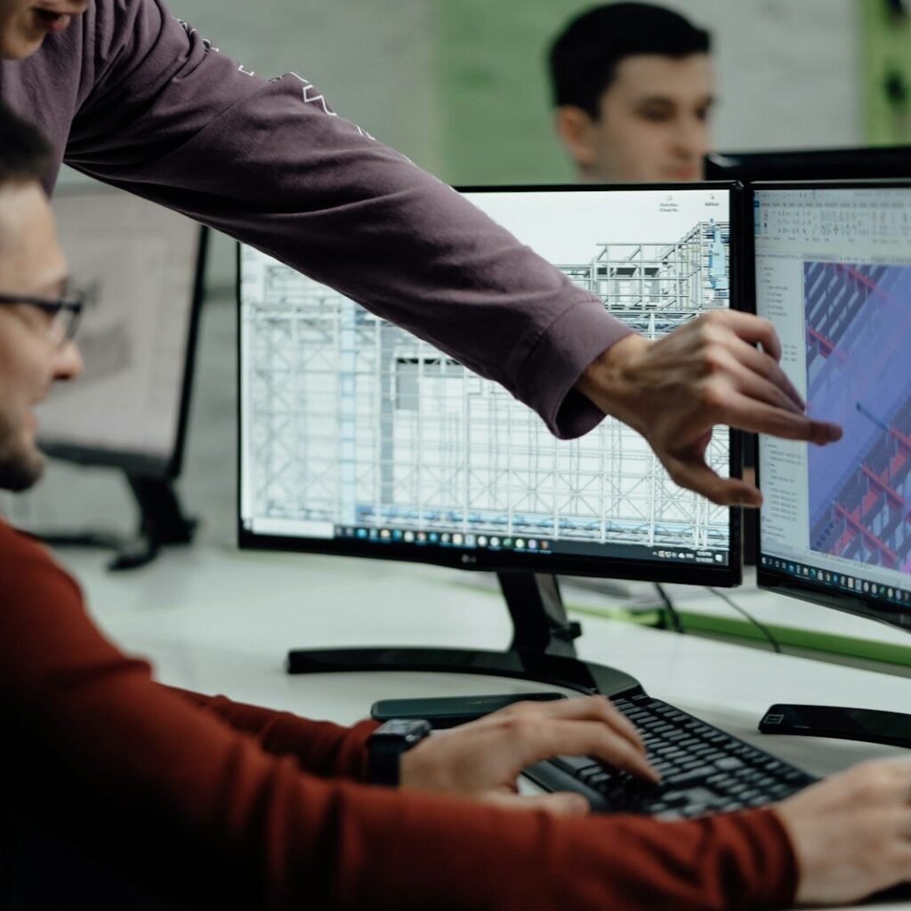 Colleagues collaborate while examining computer designs